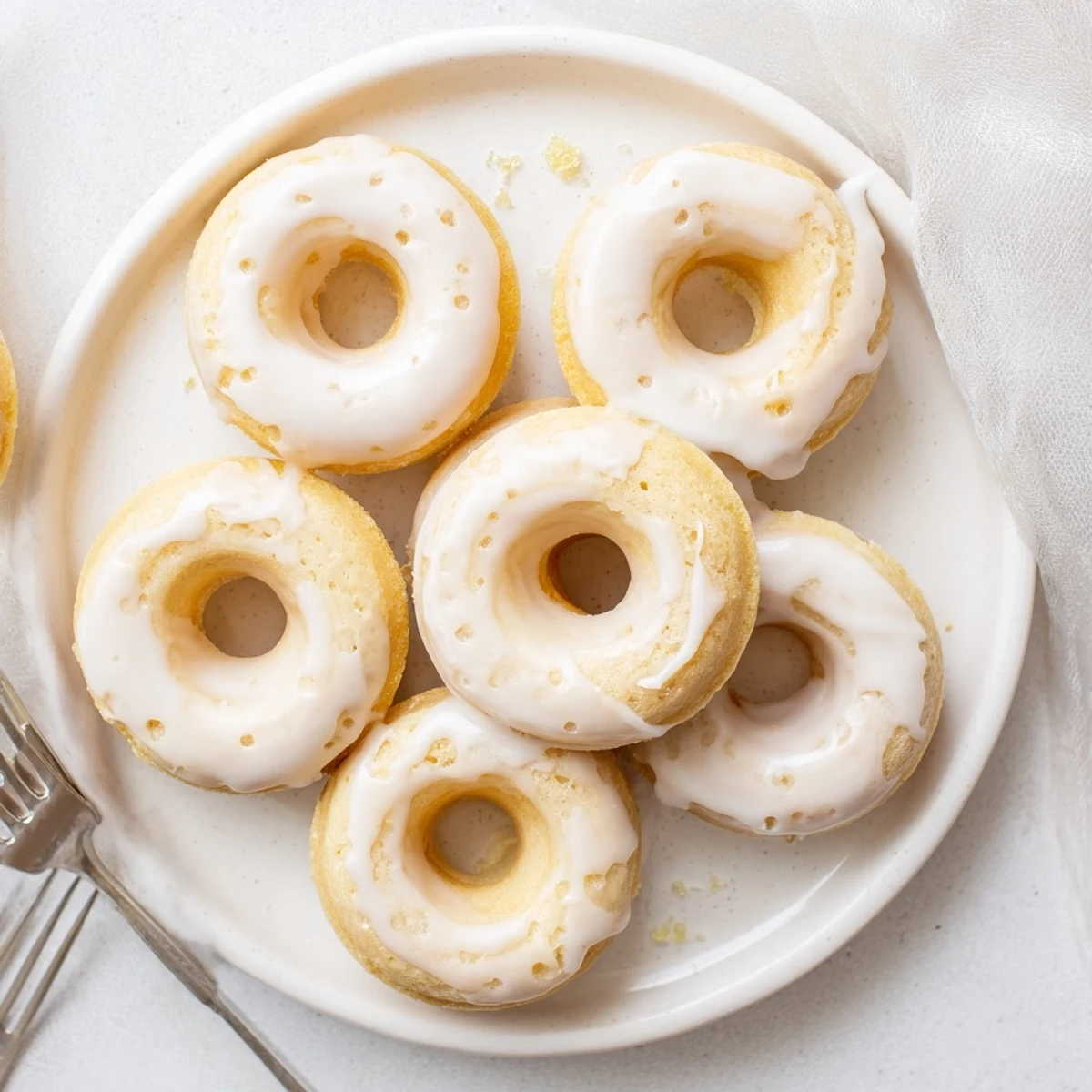 Golden glazed Greek yogurt cake donuts resting on a wire cooling rack, lightly dusted with sprinkles