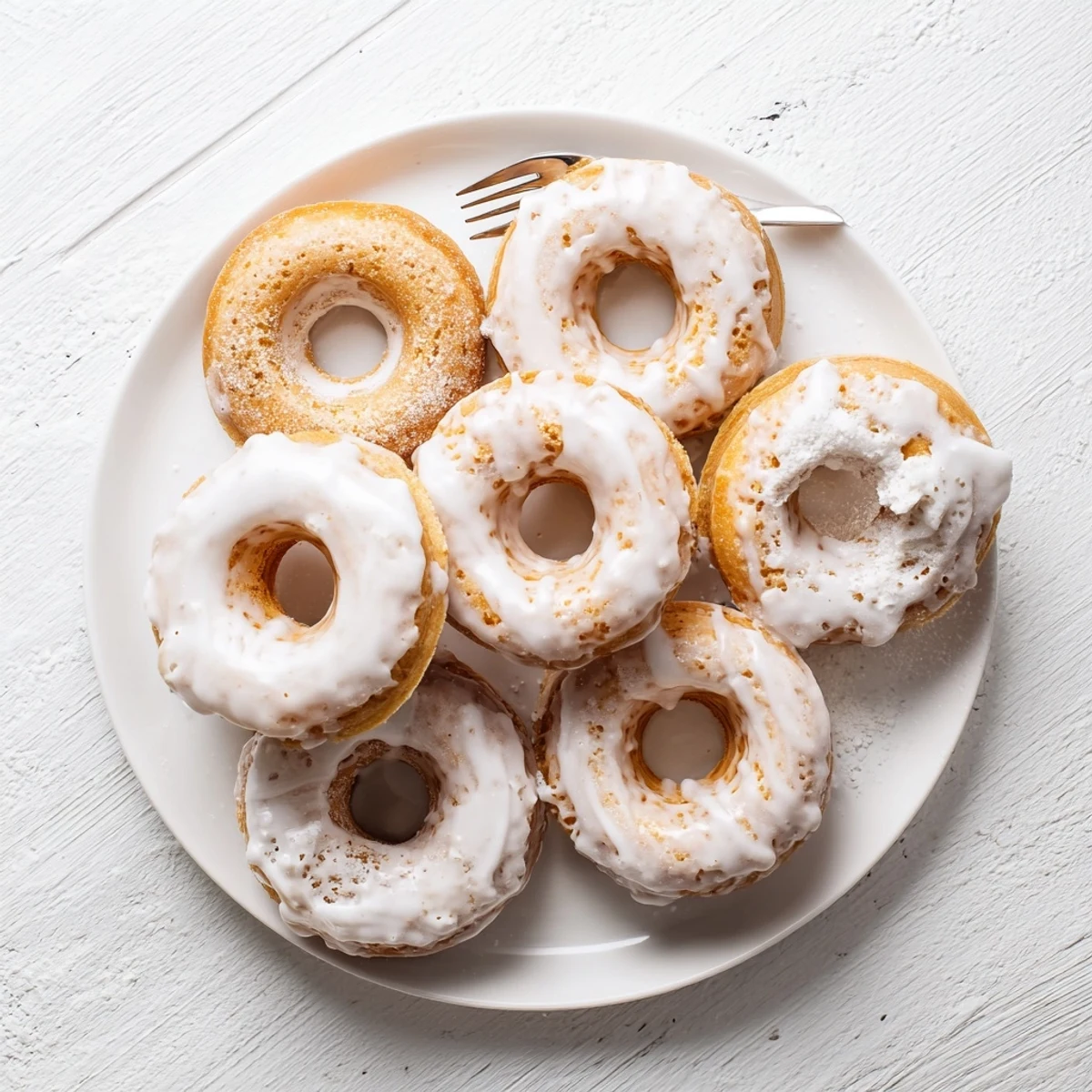 Baked Greek yogurt cake donuts with sweet vanilla glaze dripping down the sides, golden brown exterior
