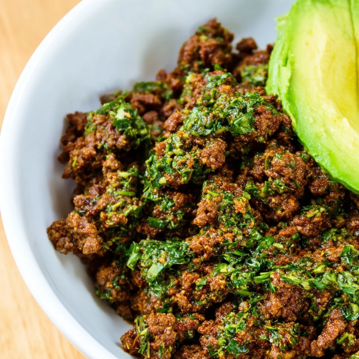 Chimichurri ground beef bowls with vibrant green sauce drizzled over seasoned meat and fluffy white rice