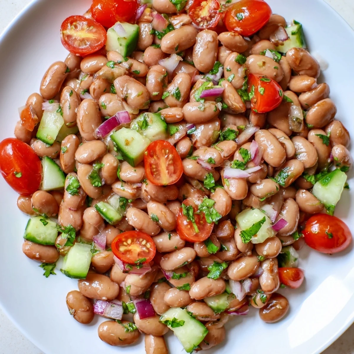 Hearty pinto bean salad topped with chopped cilantro served chilled on a rustic table