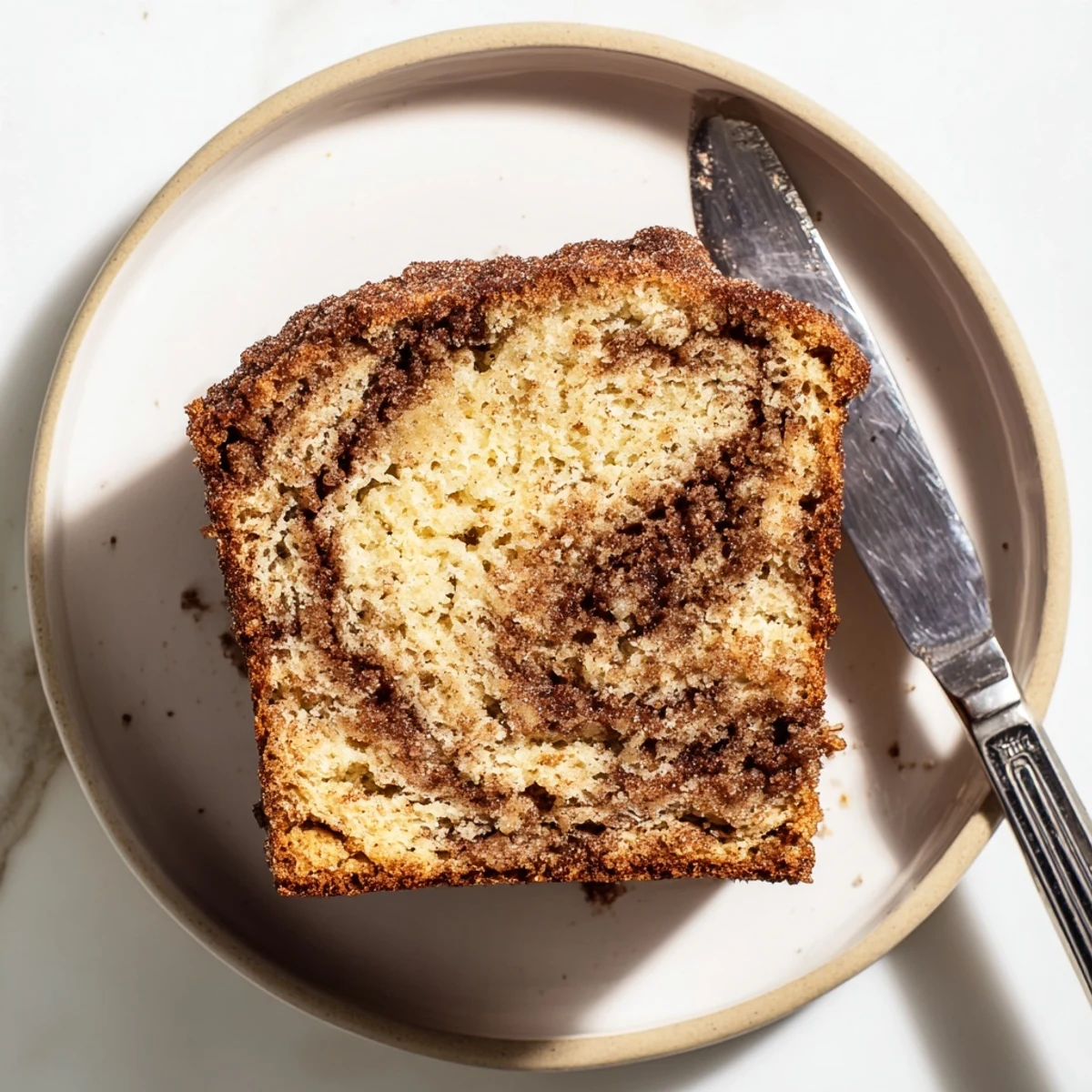 Thick slice of snickerdoodle banana bread showing a marbled cinnamon-sugar center
