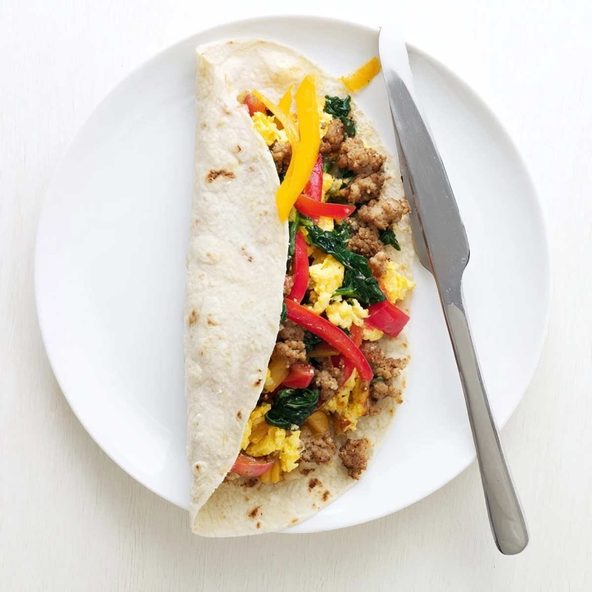 Golden freezer breakfast burritos stuffed with scrambled eggs, sausage, and melted cheddar