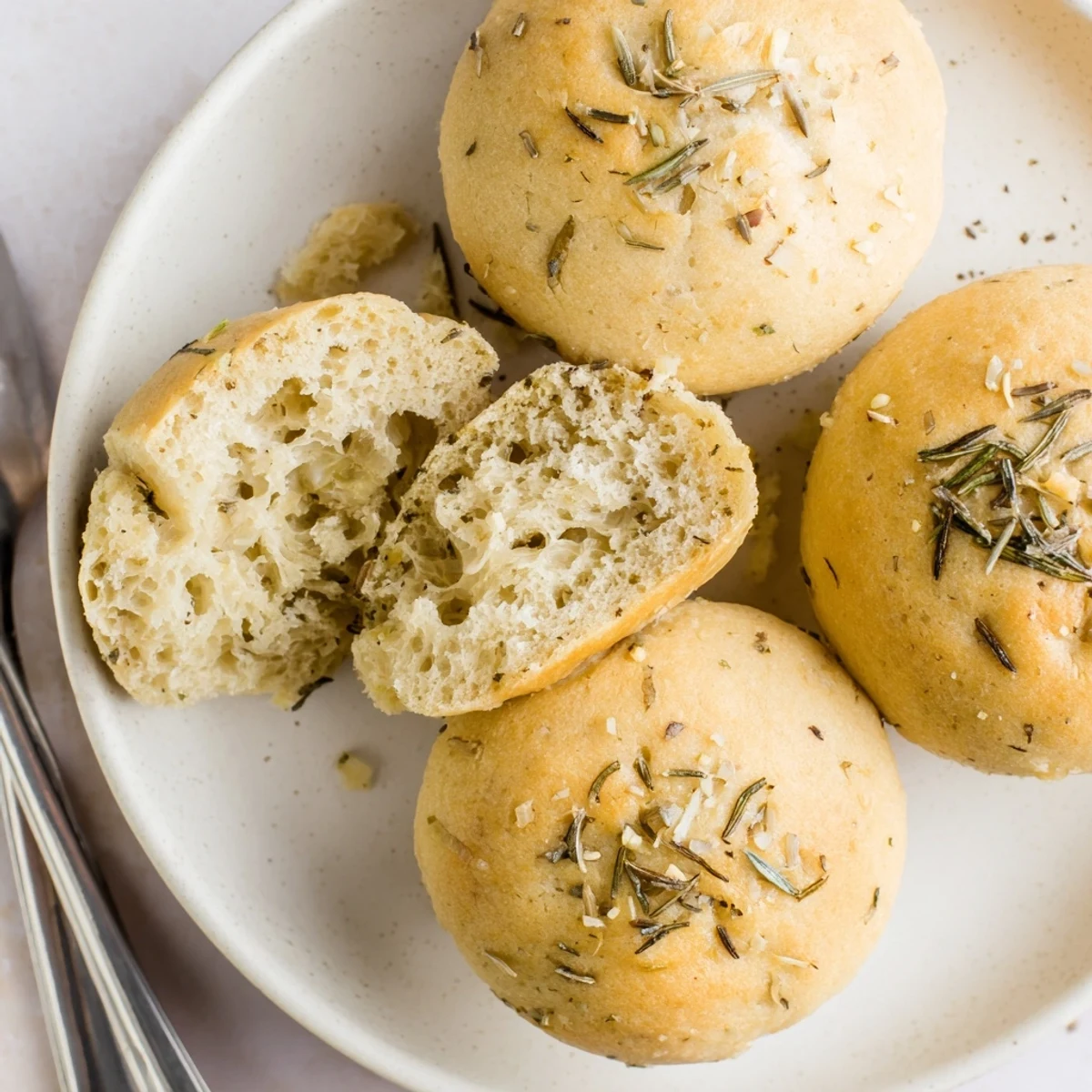 Warm Garlic Rosemary Focaccia Muffins glistening with olive oil, sprinkled with rosemary
