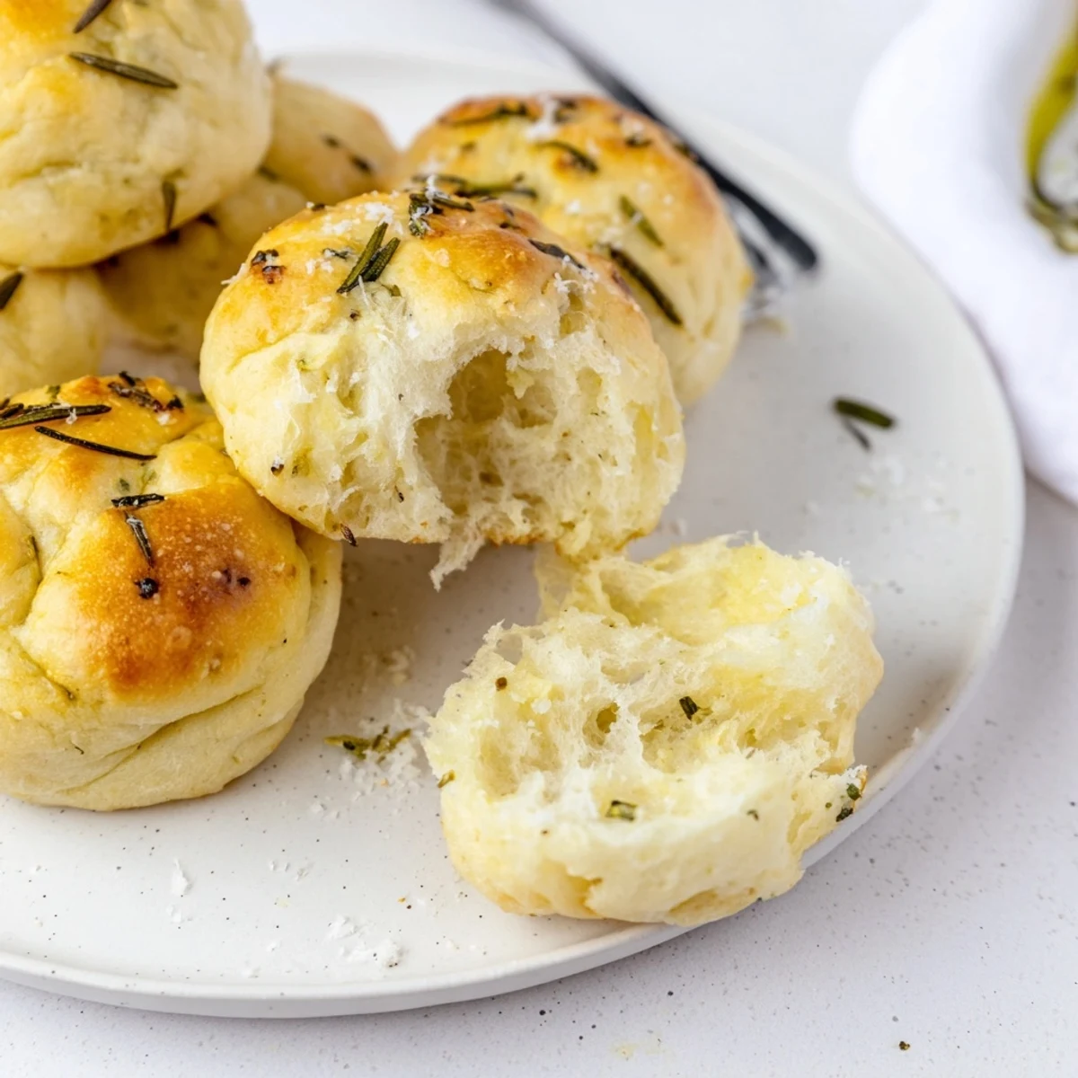 Fresh-baked Garlic Rosemary Focaccia Muffins served with soup, displaying a golden crust