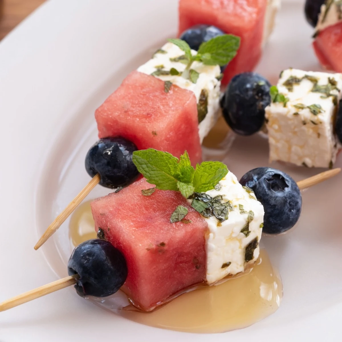 Patriotic Watermelon Feta Skewers drizzled with honey and mint, refreshing summer bites