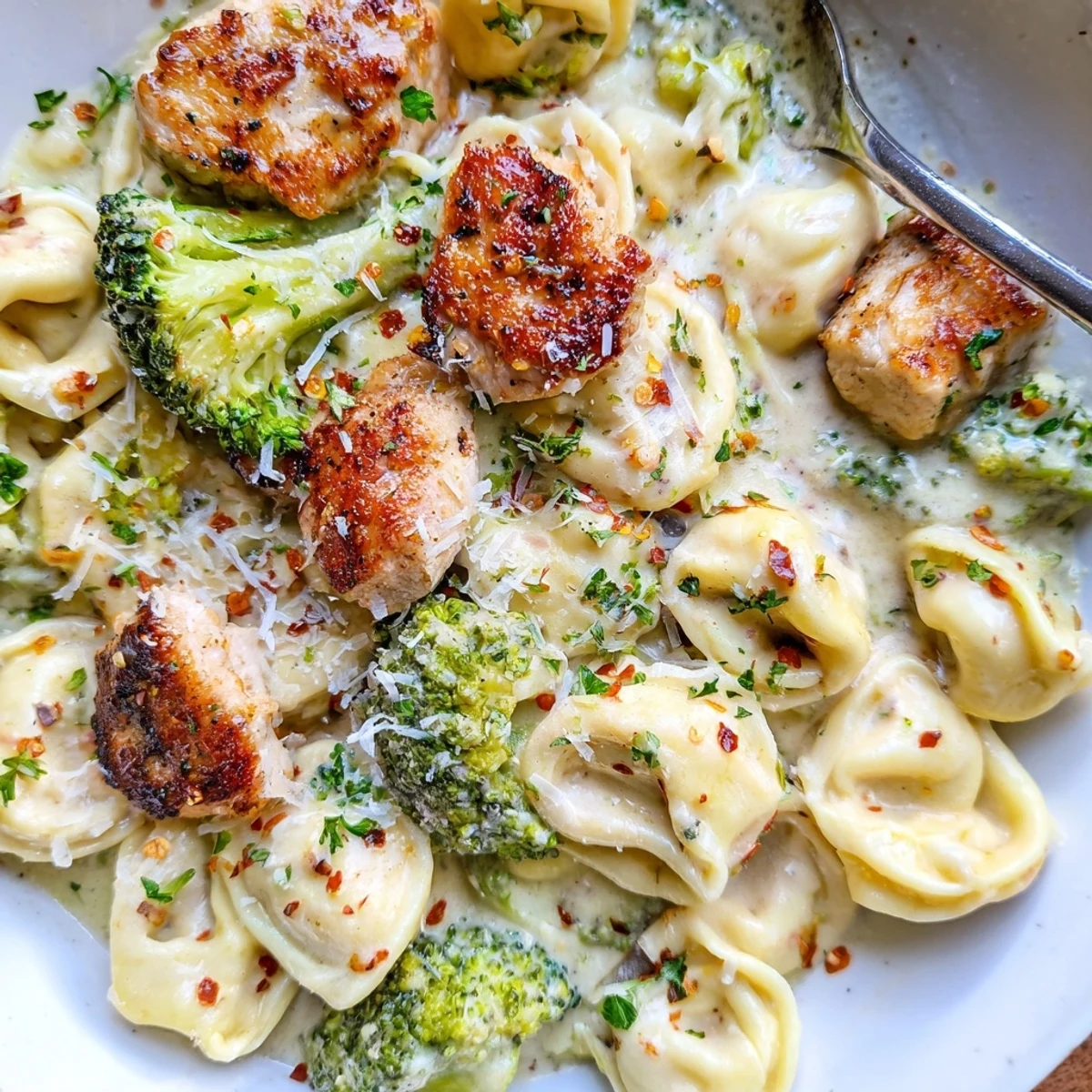 Creamy Garlic Parmesan Tortellini Chicken Broccoli Recipe simmered in silky sauce, topped with Parmesan