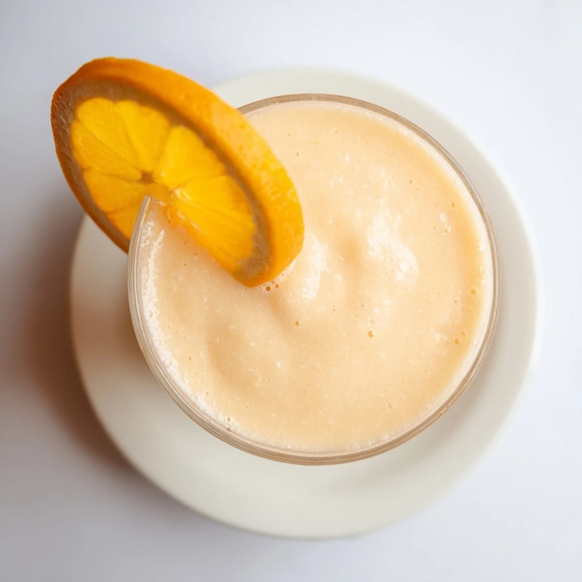 Creamy orange slush with ice crystals and zest, served in chilled glass with mint