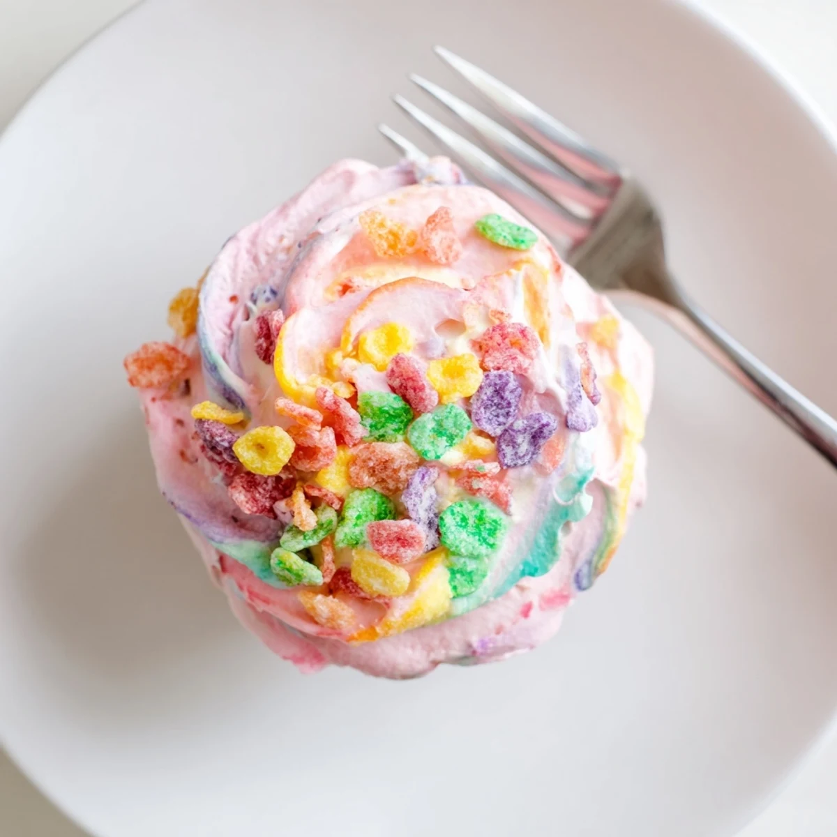 Colorful Fruity Pebbles cereal frosting piped onto chocolate cupcakes with rainbow cereal sprinkles on top