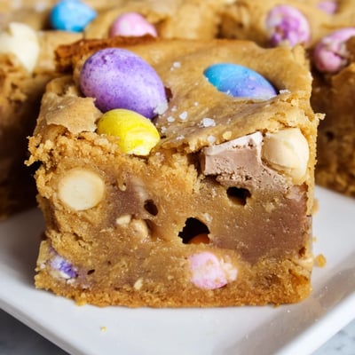 Chewy homemade mini Cadbury Easter egg blondies cut into squares showing rich buttery interior